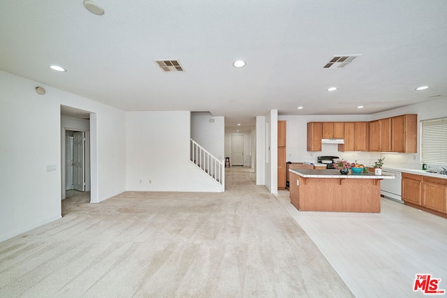 kitchen with light carpet, a kitchen island, white dishwasher, and a breakfast bar