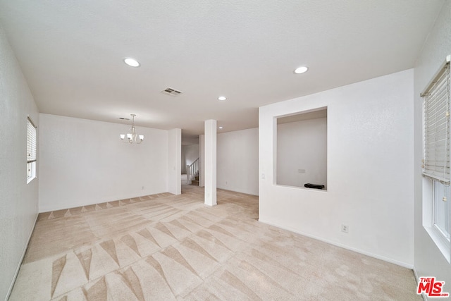 basement with light carpet and an inviting chandelier