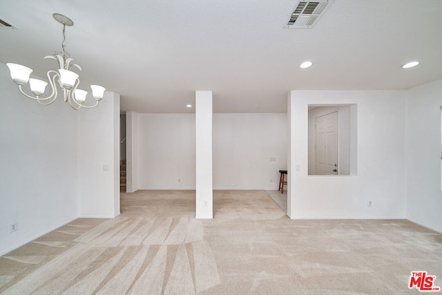 basement with light carpet and a notable chandelier