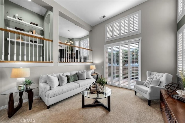 living room featuring carpet floors and a chandelier