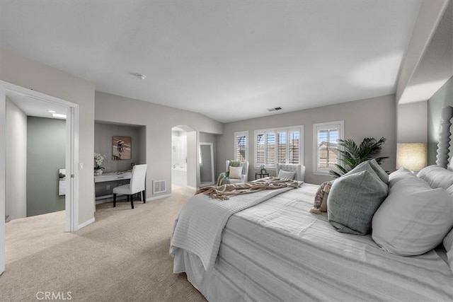 bedroom featuring light colored carpet and connected bathroom