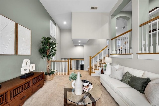 carpeted living room featuring a high ceiling