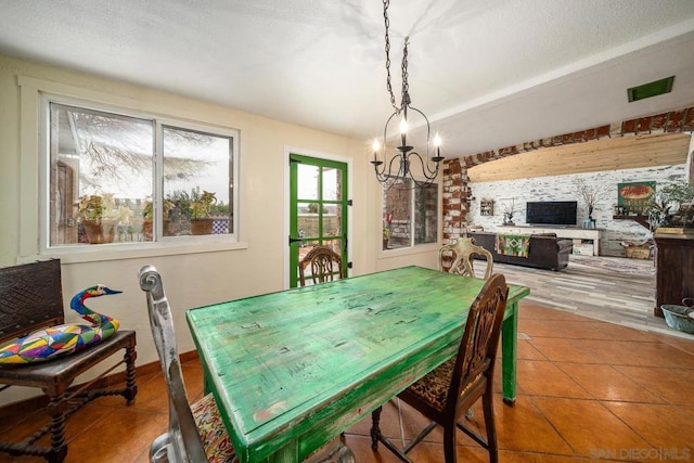 dining room with a textured ceiling, a chandelier, and tile patterned floors