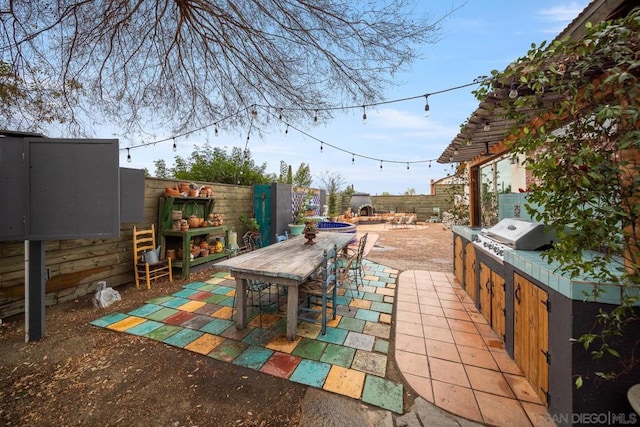 view of patio / terrace featuring exterior kitchen, an outdoor fireplace, and grilling area