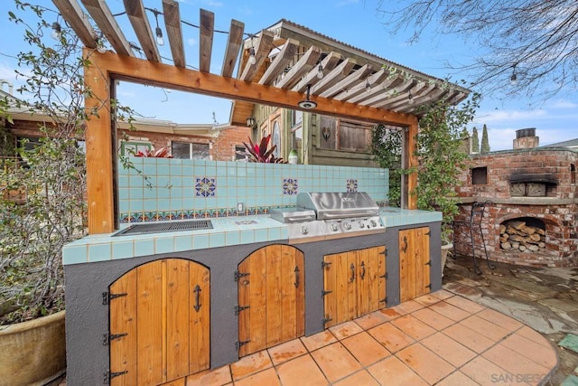 view of patio / terrace with exterior kitchen, a pergola, and grilling area