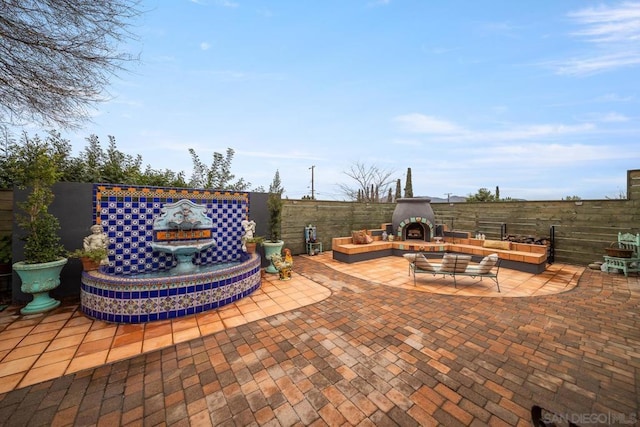 view of patio with an outdoor living space with a fireplace