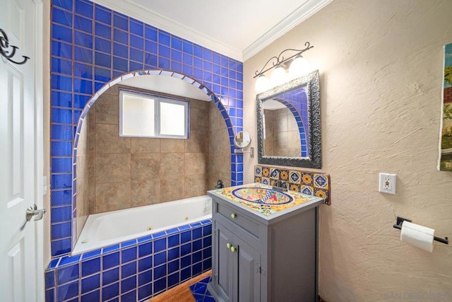 bathroom with vanity, crown molding, and a relaxing tiled tub