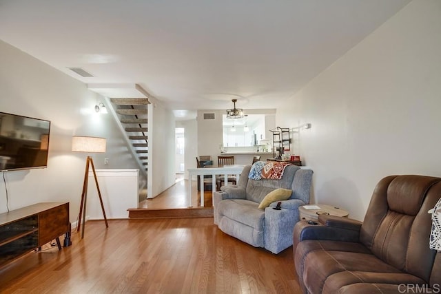 living room with wood-type flooring and a chandelier