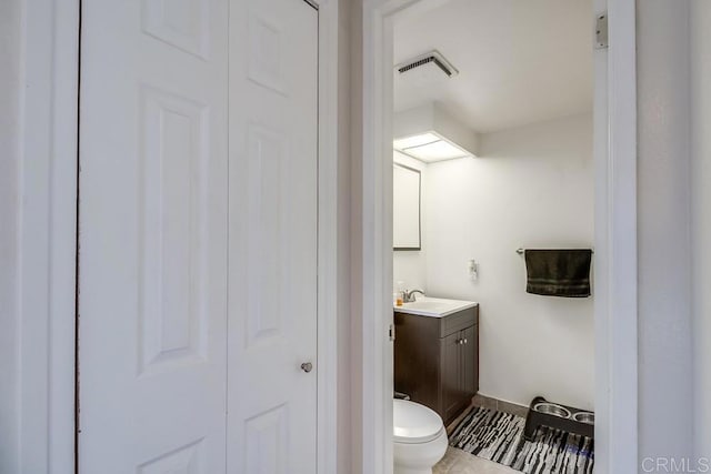 bathroom featuring toilet, vanity, and tile patterned floors