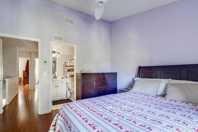 bedroom with connected bathroom and wood-type flooring