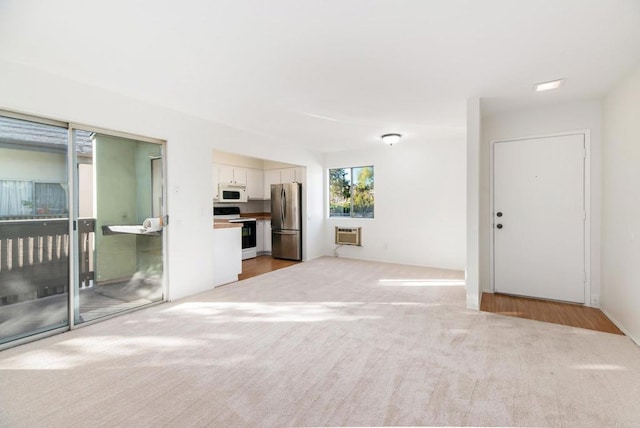 unfurnished living room featuring light carpet