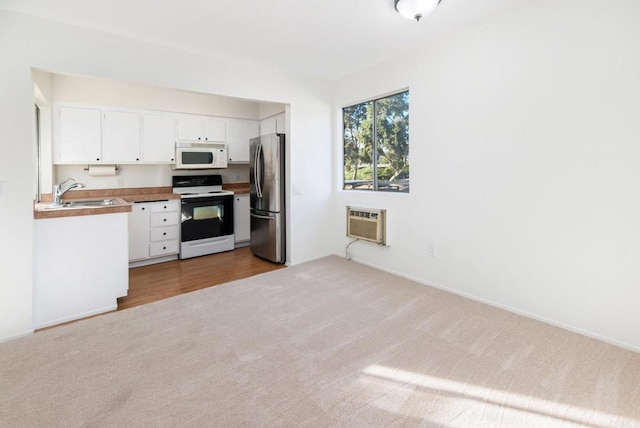 kitchen featuring light carpet, white cabinetry, stainless steel fridge, electric range, and sink