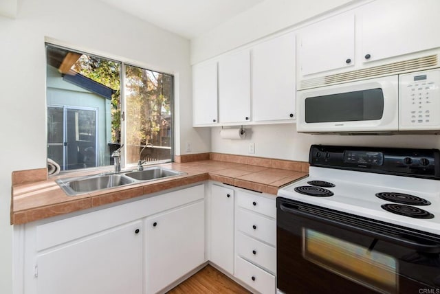 kitchen featuring sink, white cabinetry, range with electric stovetop, and light wood-type flooring