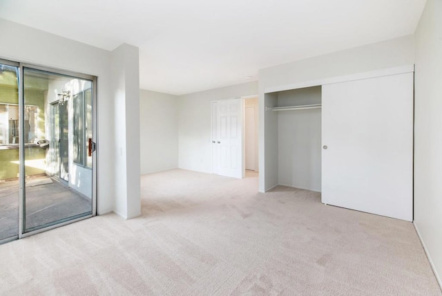 unfurnished bedroom with access to exterior, light colored carpet, and a closet