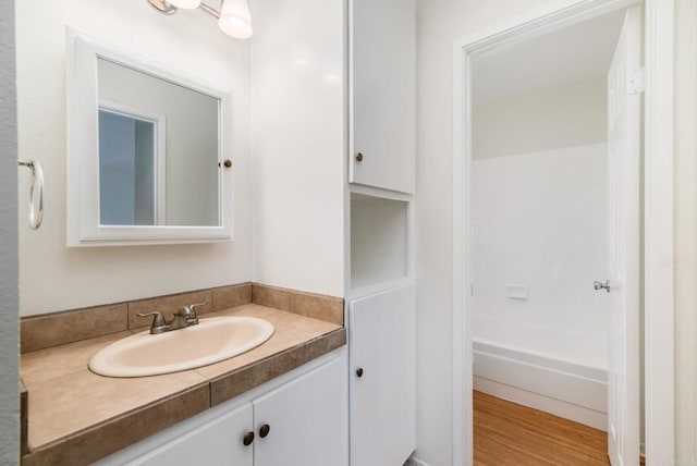 bathroom featuring a bath, hardwood / wood-style flooring, and vanity