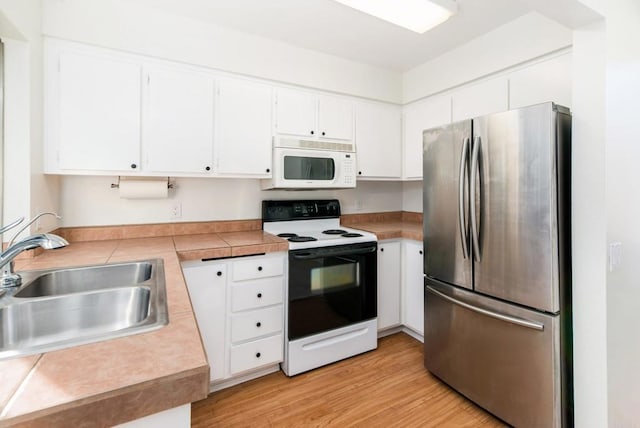 kitchen featuring light hardwood / wood-style floors, electric stove, stainless steel refrigerator, white cabinets, and sink