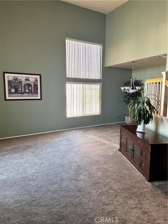 interior space with a high ceiling and carpet flooring