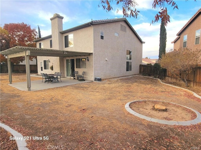 rear view of property with a pergola and a patio