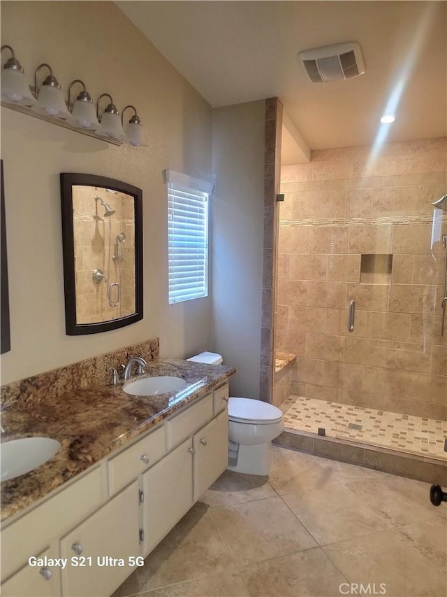 bathroom featuring vanity, tile patterned flooring, a shower with door, and toilet