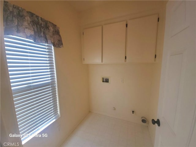 clothes washing area featuring cabinets