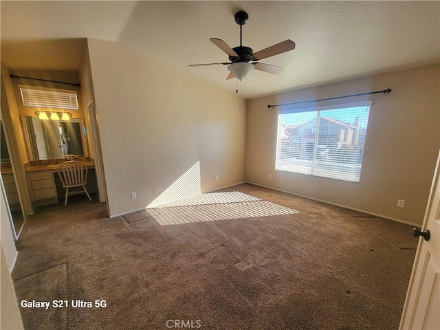 carpeted spare room featuring ceiling fan, lofted ceiling, and a textured ceiling