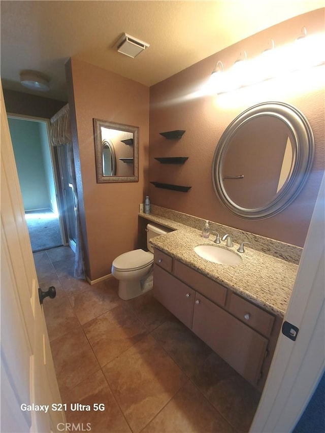 bathroom featuring vanity, tile patterned flooring, and toilet