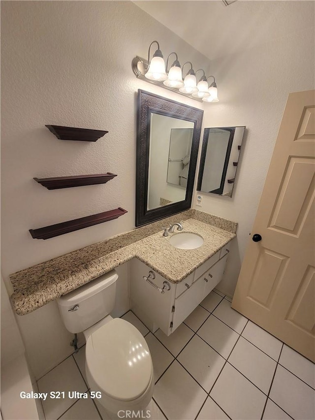 bathroom featuring tile patterned flooring, vanity, and toilet