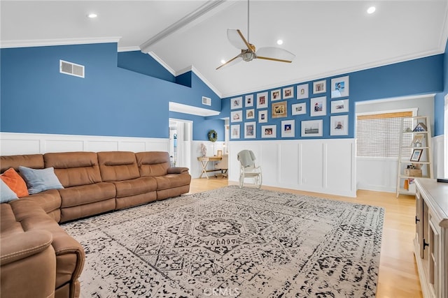 living room with ceiling fan, ornamental molding, lofted ceiling with beams, and light hardwood / wood-style flooring