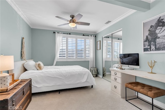 carpeted bedroom with crown molding, ceiling fan, and a closet