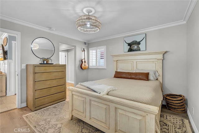 bedroom with crown molding, a notable chandelier, and light hardwood / wood-style flooring