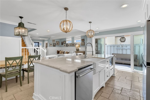 kitchen with pendant lighting, white cabinetry, a center island with sink, stainless steel dishwasher, and a chandelier