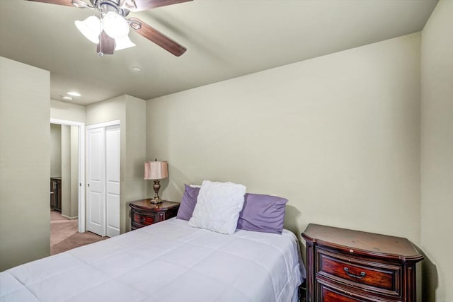 carpeted bedroom featuring ceiling fan and a closet