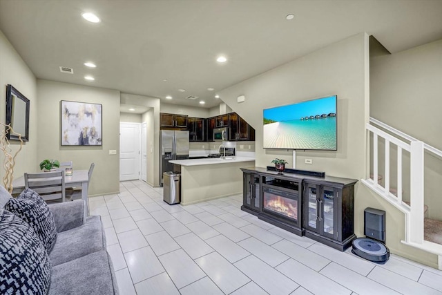 kitchen with stainless steel appliances, dark brown cabinets, and sink