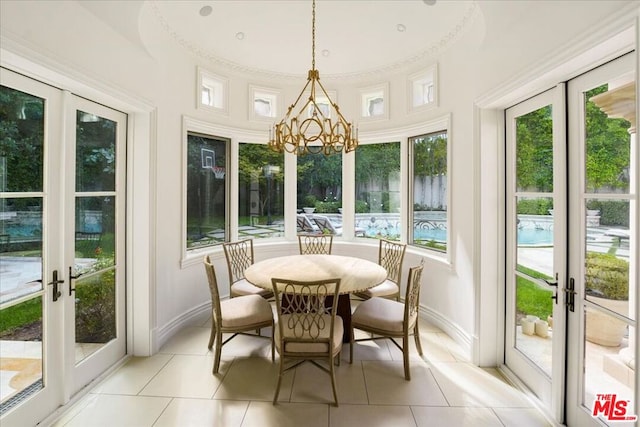 sunroom featuring an inviting chandelier and french doors