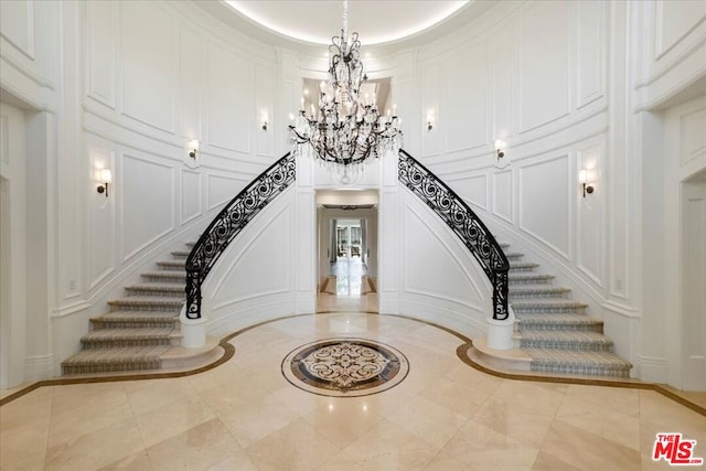 stairs featuring ornamental molding and a chandelier