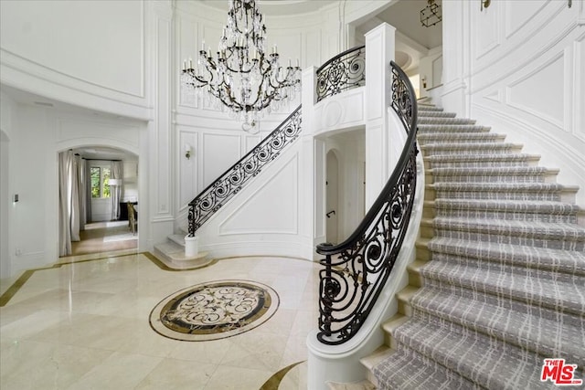 stairway featuring a chandelier and a high ceiling