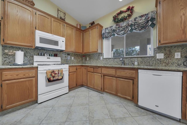 kitchen featuring light tile patterned flooring, sink, white appliances, and tasteful backsplash