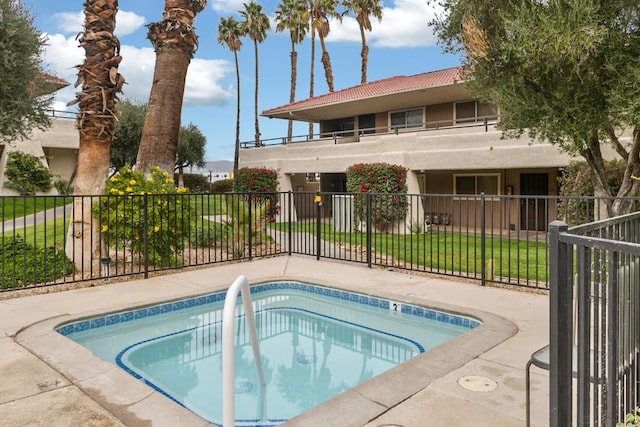 view of swimming pool with a lawn and a community hot tub