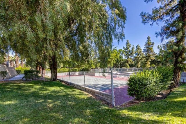 view of sport court with a lawn