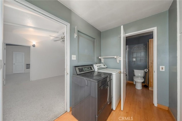 washroom with ceiling fan, light colored carpet, and washing machine and clothes dryer