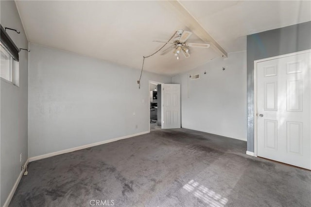 empty room featuring ceiling fan, vaulted ceiling with beams, and dark carpet