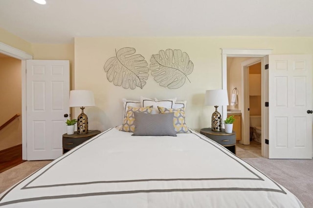 bedroom featuring light carpet and ensuite bathroom