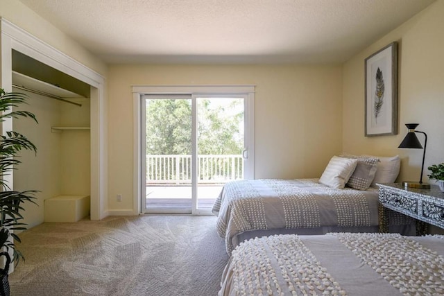 carpeted bedroom with a textured ceiling, a closet, and access to outside