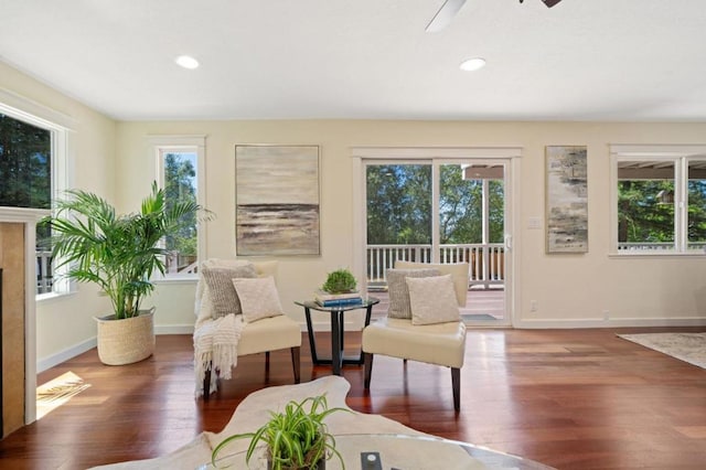 living area featuring ceiling fan, a healthy amount of sunlight, and dark hardwood / wood-style floors