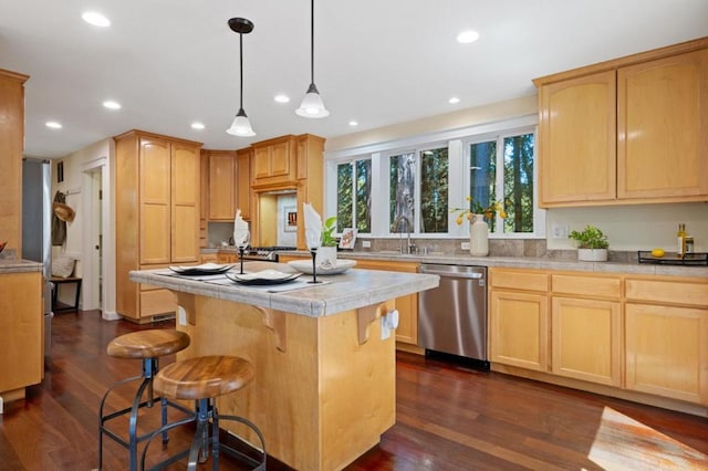 kitchen with dark hardwood / wood-style floors, light brown cabinetry, dishwasher, hanging light fixtures, and a center island