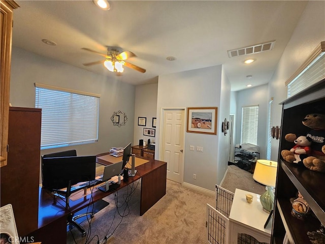 carpeted office space with ceiling fan