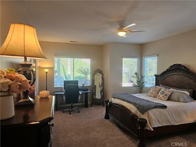 carpeted bedroom featuring ceiling fan and multiple windows