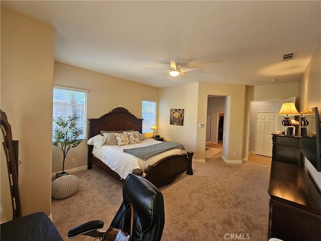 carpeted bedroom featuring ceiling fan and multiple windows