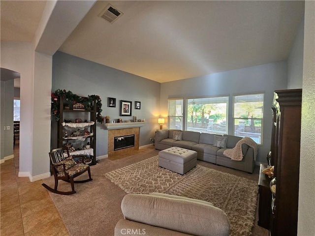 living room with a tiled fireplace and tile patterned floors