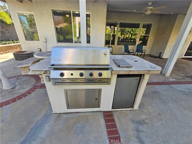 view of patio / terrace featuring ceiling fan, an outdoor kitchen, and grilling area